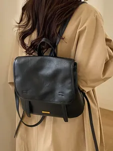 Zaino vintage in ecopelle nera con logo metallico ed eleganti dettagli di texture pieghe