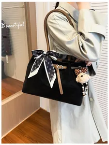 Detailed view of black matte leather tote with floral silk scarf and puppy charm
