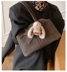 Sac cabas rétro en daim marron avec pendentif lapin en peluche porté à l'épaule