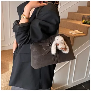 Détail du sac fourre-tout marron foncé avec boucle de ceinture et charm lapin en peluche
