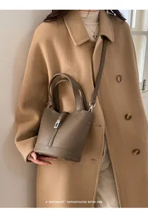 Elegante borsa a secchiello taupe con chiusura in metallo e trama in pelle martellata
