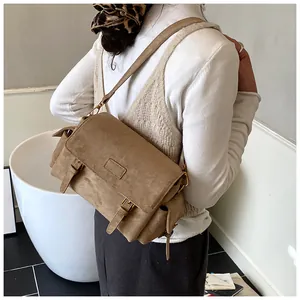 Brown suede Boston bag detail showing the adjustable shoulder strap and side pocket