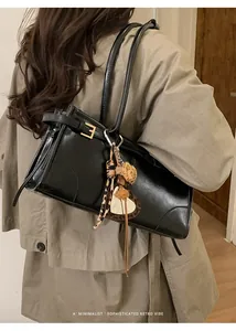 Détail du sac cabas vintage noir avec breloque léopard et finition en similicuir lisse