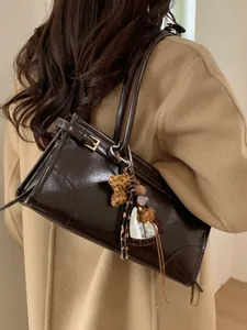 Sac fourre-tout rétro marron brillant avec nœud léopard porté par un mannequin chic