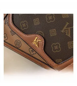 Close-up of vintage baguette bag with floral monogram pattern and golden K-logo