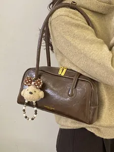 Vintage brown leather Boston handbag for women with plush puppy charm and golden hardware