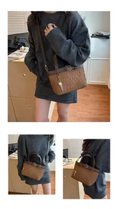 Detail of brown pleated bucket bag showing gold hardware and key pendant accessory