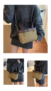 Detail of khaki pleated bucket bag with brown leather trim and key pendant