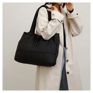 Détail du sac cabas matelassé noir avec cordon de serrage et larges bretelles épaisses