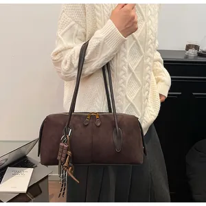 Vue détaillée du cabas en daim marron avec pendentif chocolat porté à l'épaule
