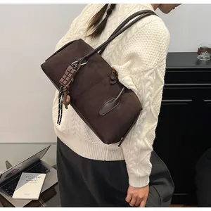 Vue détaillée du sac cabas en daim marron foncé avec charm chocolat et deux bandoulières