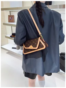 Detail showing the brown vintage baguette bag with gold K-hardware and patterned texture