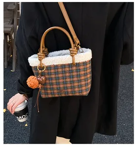Détail du sac seau à carreaux vintage avec bordure en peluche et anses en cuir marron