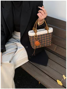 Détail du sac seau à carreaux avec bordure en simili mouton et poignée en cuir