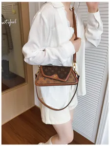 Detailed view of vintage baguette bag featuring brown monogram pattern and gold metal hardware