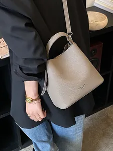 Elegante borsa a secchiello taupe in pelle martellata con manico e tracolla