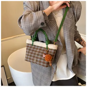 Détail du sac seau à carreaux avec bordure en peau lainée et charms tendance