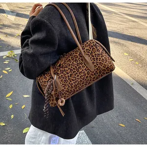 Photo de rue d'un sac à bandoulière cylindrique à motif léopard porté avec un manteau