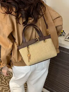 Minimalist beige pleated bucket bag with brown leather trim and golden key charm