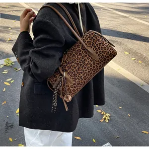Détail du sac cabas imprimé léopard avec pendentif marron et fines bandoulières