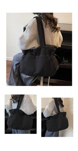 Close-up of black corduroy tote bag featuring adjustable drawstring side and front pocket