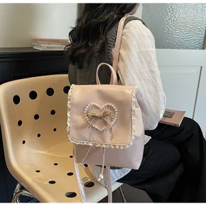 Detailed view of pink PU leather backpack with lace trim and pearl heart decoration