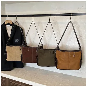 Detail view of retro suede tote bags in khaki, brown, green and caramel tones