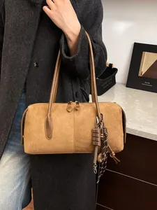 Sac fourre-tout en daim marron avec longues anses et breloque chocolat sur mannequin