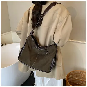 Close-up of vintage brown suede tote bag with contrast leather trim and stitching
