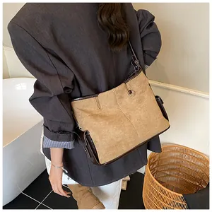 Detail of vintage tote bag showing brown suede texture and dark leather stitching