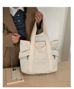 Λεπτομέρεια μεγάλης υφασμάτινης τσάντας tote με πλαϊνά φερμουάρ και φαρδιούς ιμάντες ώμου