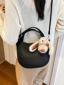 Retro black litchi pattern crescent bucket bag with a cute white bunny plush pendant