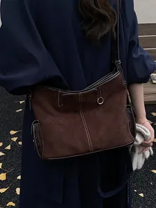 Deep brown suede hobo tote bag with contrast stitching and metal ring on shoulder strap