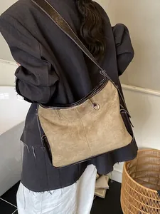 Retro khaki suede tote bag with brown trim and metal ring detail worn by a model