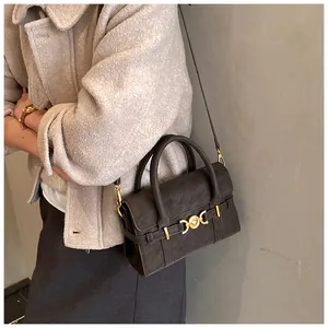 Dettaglio borsa quadrata in camoscio grigio con chiusura vintage dorata e tracolla