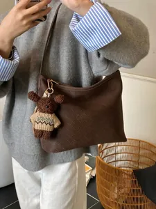 Deep brown woven tote bag with a cute teddy bear charm for autumn and winter outfits