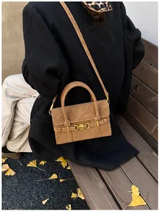 Dettaglio di una borsa vintage in pelle scamosciata color cammello con fibbia oro