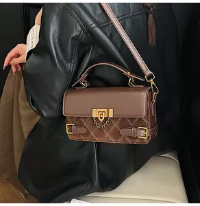 Detail of retro quilted shoulder bag showing textured suede and gold chain lock