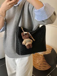 Black woven leather tote bag with a cute brown teddy bear charm shown in a mirror selfie