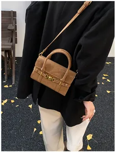 Dettaglio di una borsa a tracolla in pelle scamosciata marrone con fibbia dorata vintage