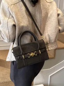 Borsa a tracolla grigio scuro testurizzata con dettagli dorati indossata da modella
