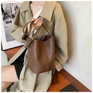 Vue détaillée du sac seau en cuir grainé marron foncé avec fermoir doré élégant