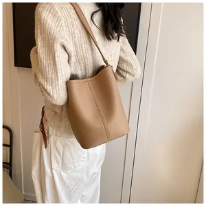 Gros plan d'un sac seau kaki montrant le grain de cuir lychee et les coutures verticales