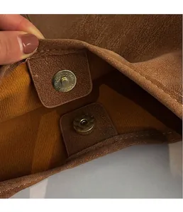 Detailaufnahme des goldenen Magnetverschlusses an der braunen Leder-Einkaufstasche