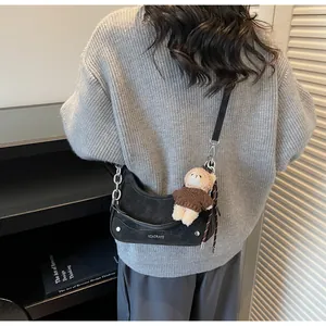 Detailansicht der schwarzen Wildledertasche mit Silberkette und Bärenanhänger