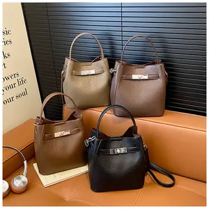 Close-up of four textured leather bucket bags with silver metallic turn-lock clasps
