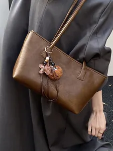 Borsa tote marrone in pelle con scritta goffrata e ciondolo a stella in peluche