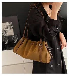Detalle del bolso de hombro plisado vintage en cuero marrón con cordón ajustable