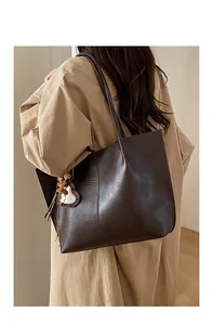 Detailed macro view of vintage wrinkled leather texture on a dark brown tote bag