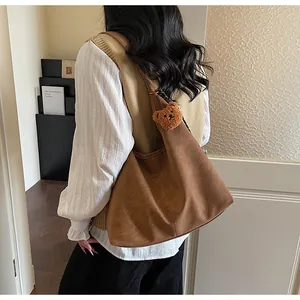 Bruine leren shopper met een schattige teddybeer hanger in een sfeervol interieur